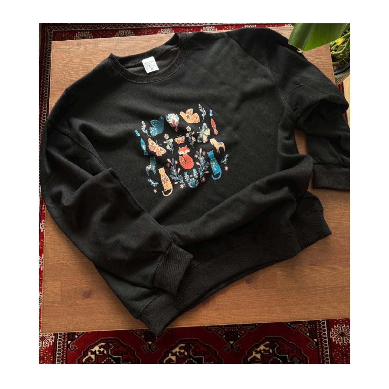 Cozy Black Sweatshirt with Whimsical Woodland Animal and Floral Design – Fox, Cat, and Bird Pattern